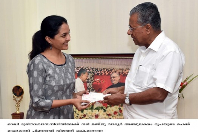 Chief Minister Pinarayi Vijayan receiving donation from Manju Warrier