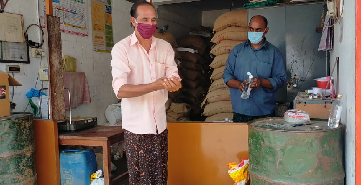 റേഷന്‍ കടയില്‍ എത്തുന്ന ഉപഭോക്താക്കള്‍ സാനിട്ടറൈസര്‍ ഉപയോഗിച്ച് കൈകള്‍ ശുചീകരിക്കുന്നു.