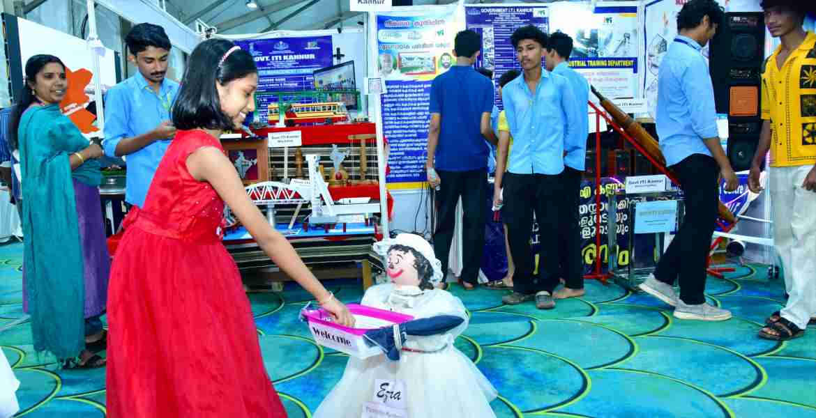 കണ്ണൂർ ഗവ. ഐടിഐ യിലെ മെക്കാനിക്കൽ ആൻഡ് ഇലക്ട്രോണിക്ക്സ് വിദ്യാർത്ഥികൾ തയ്യാറാക്കിയ 'എസ്ര' എന്ന പേര് നൽകിയ റോബോട്ട് സന്ദർശകർക്ക് ചോക്ലേറ്റ് നൽകുന്നു