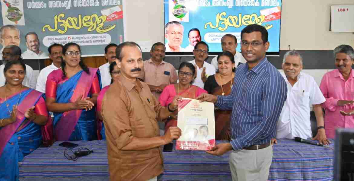 ധർമ്മടം അസംബ്ലി നിയോജകമണ്ഡലം പട്ടയമേള പിണറായി കൺവൻഷൻ സെൻ്ററിൽ റവന്യു മന്ത്രി കെ രാജൻ ഓൺലൈനിൽ ഉദ്ഘാടനം ചെയ്ത ശേഷം കലക്ടർ അരുൺ കെ വിജയൻ പിണറായി ഗ്രാമപഞ്ചായത്ത് പ്രസിഡൻ്റ് കെ കെ രാജീവന് പട്ടയം നൽകുന്നു