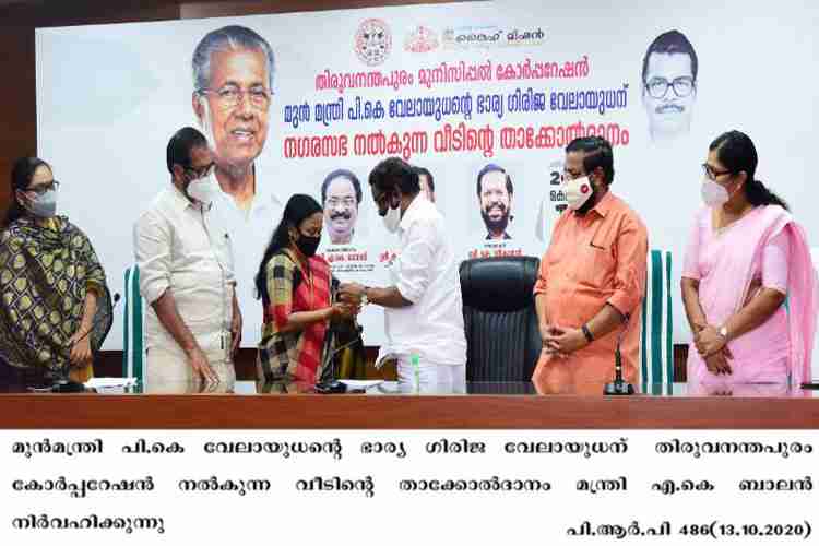 Minister AK Balan presents the house key to beneficiary